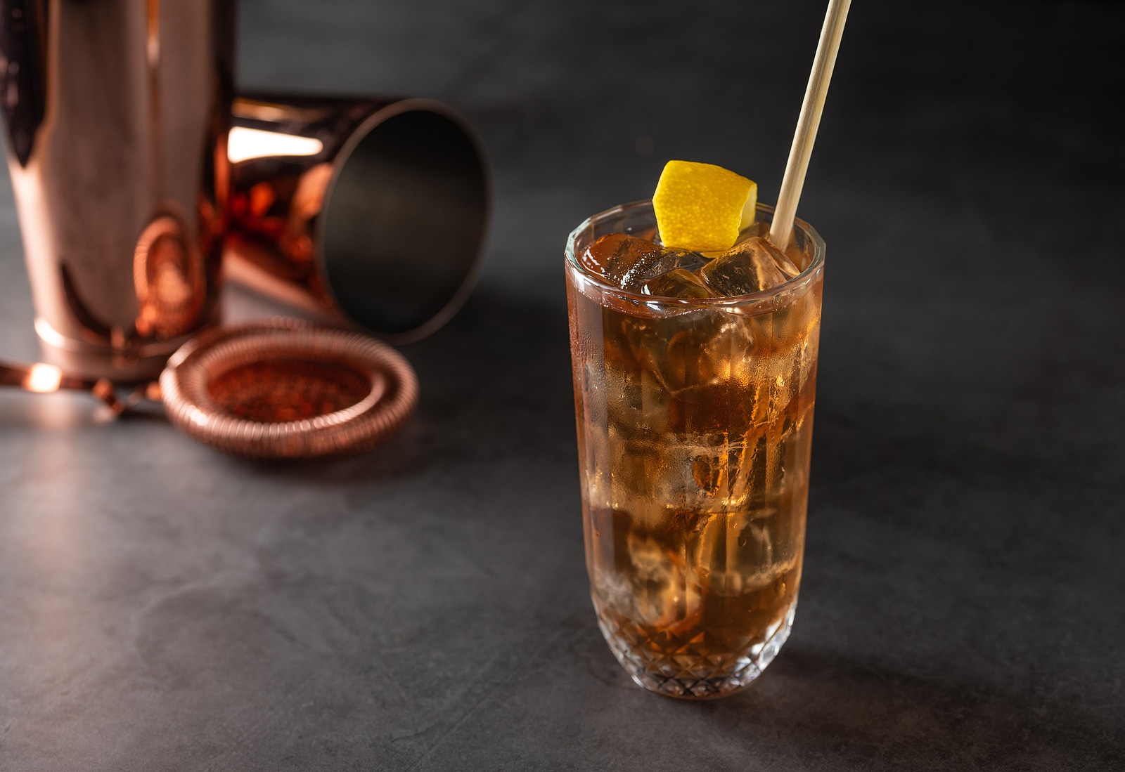 Luxury cocktail and cocktail shaker on black stone background.