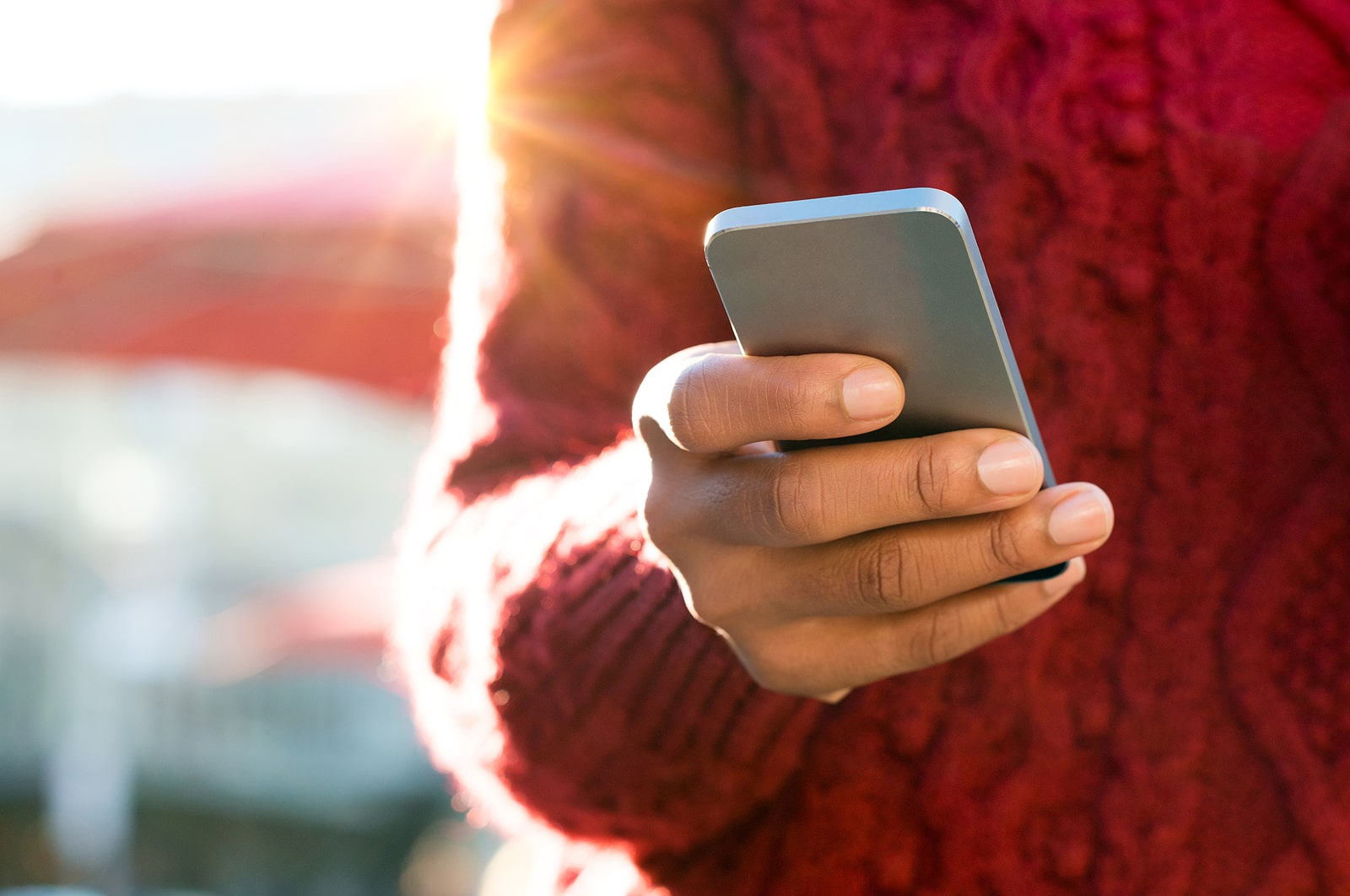 Close up of a young woman's hand typing text message on her smartphone. 