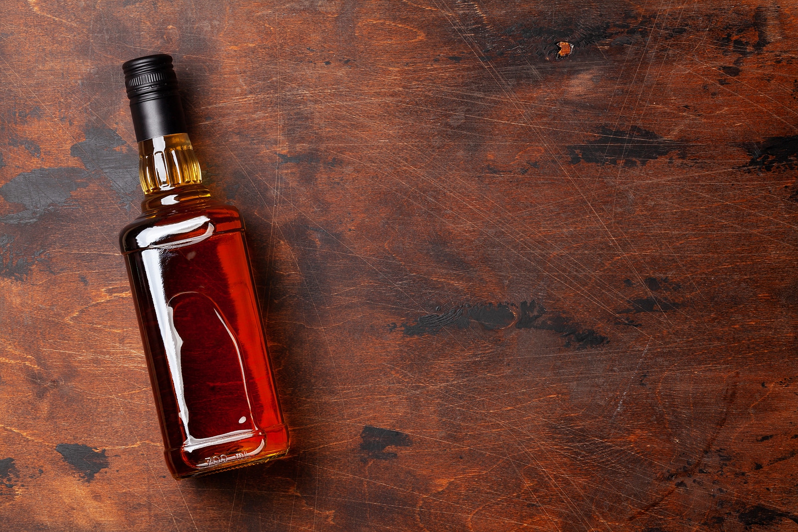 Scotch whiskey bottle on wooden table. 