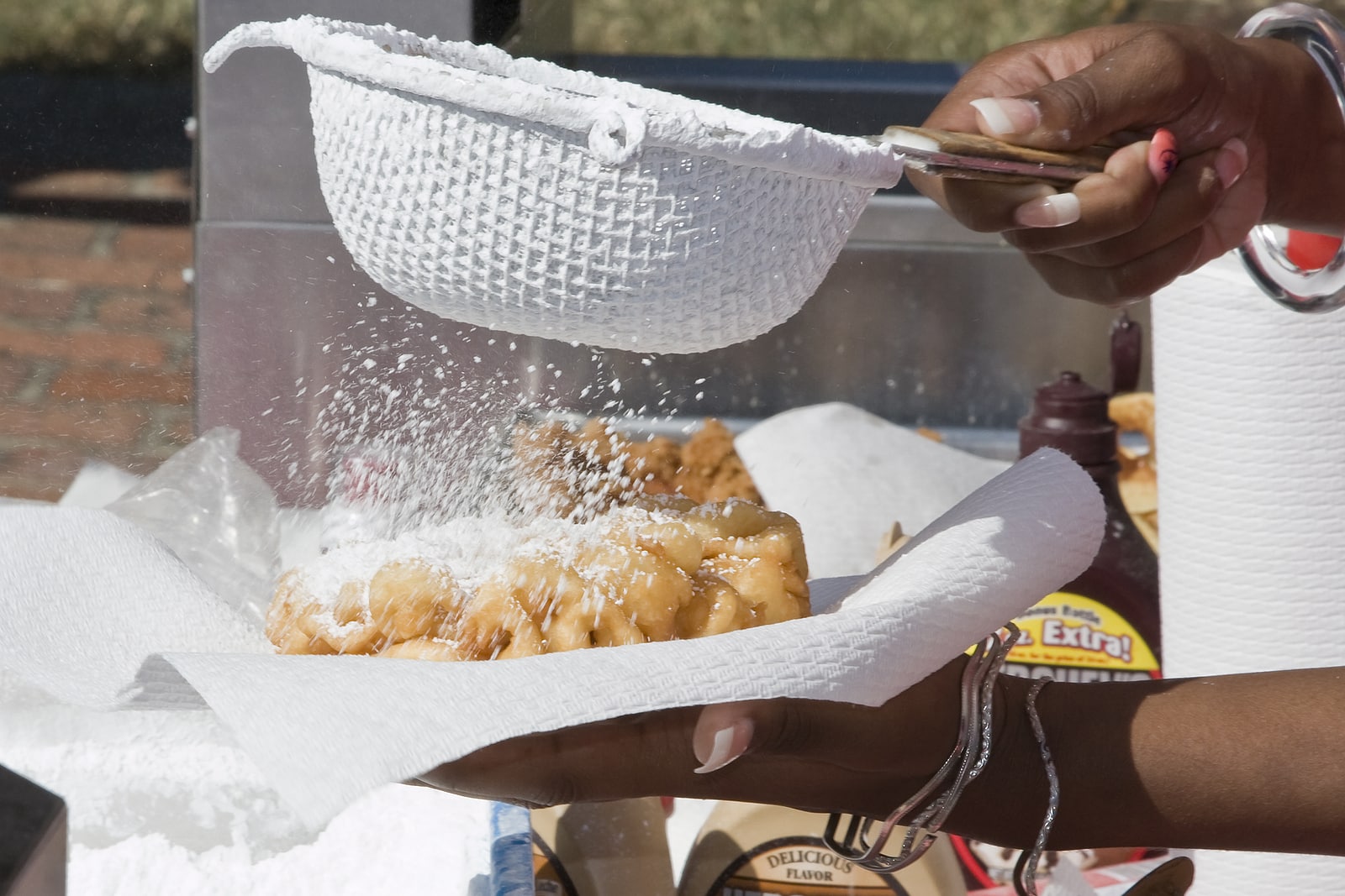 Young lady making fresh funnel cakes popular at fair time and other gatherings.