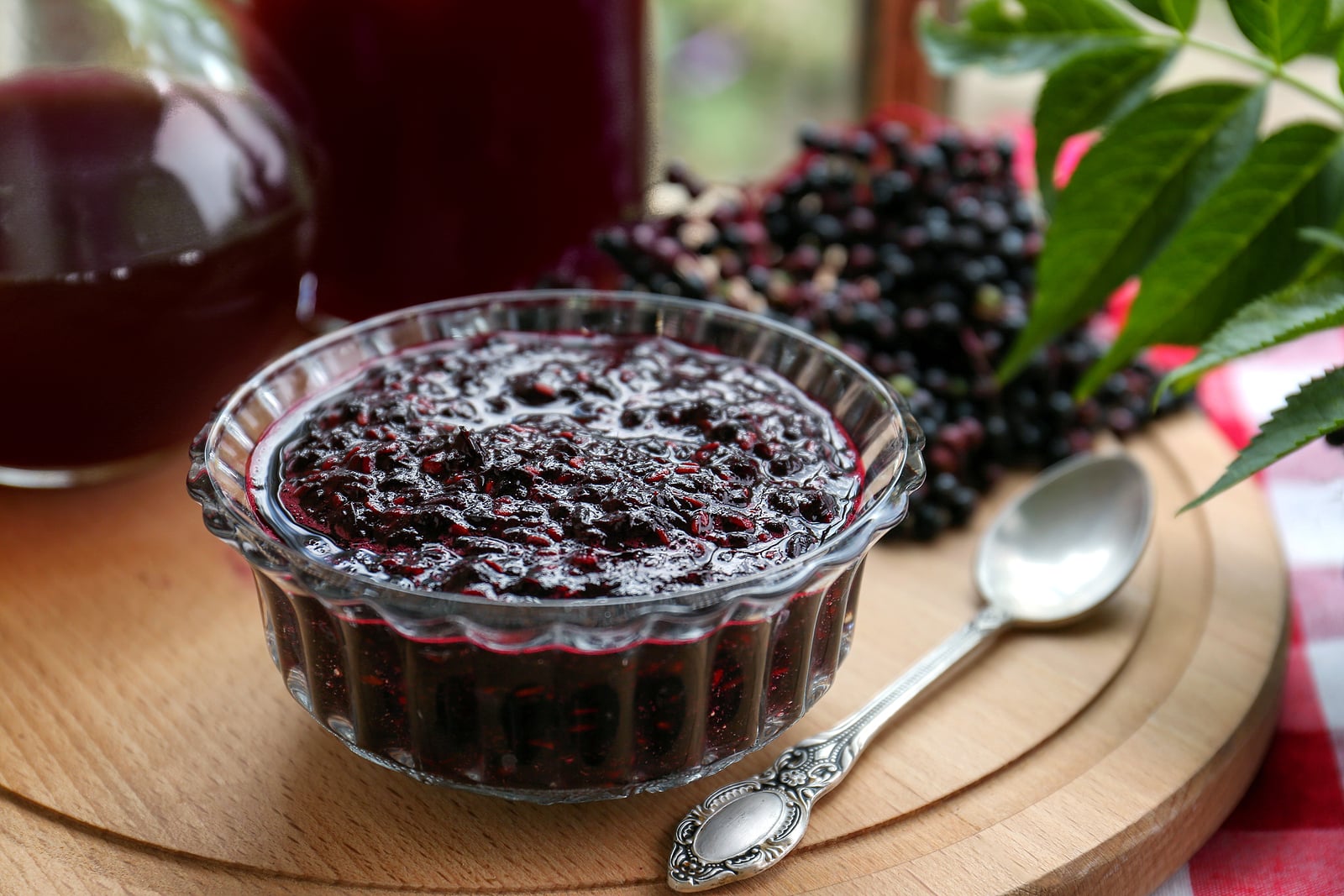 Elderberry jam and drink with Sambucus berries on table.