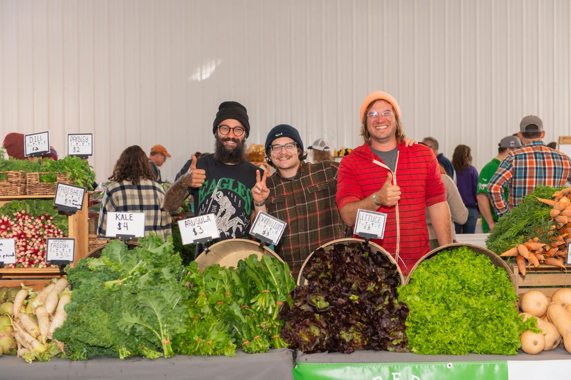 Guys smiling with produce at GFF.