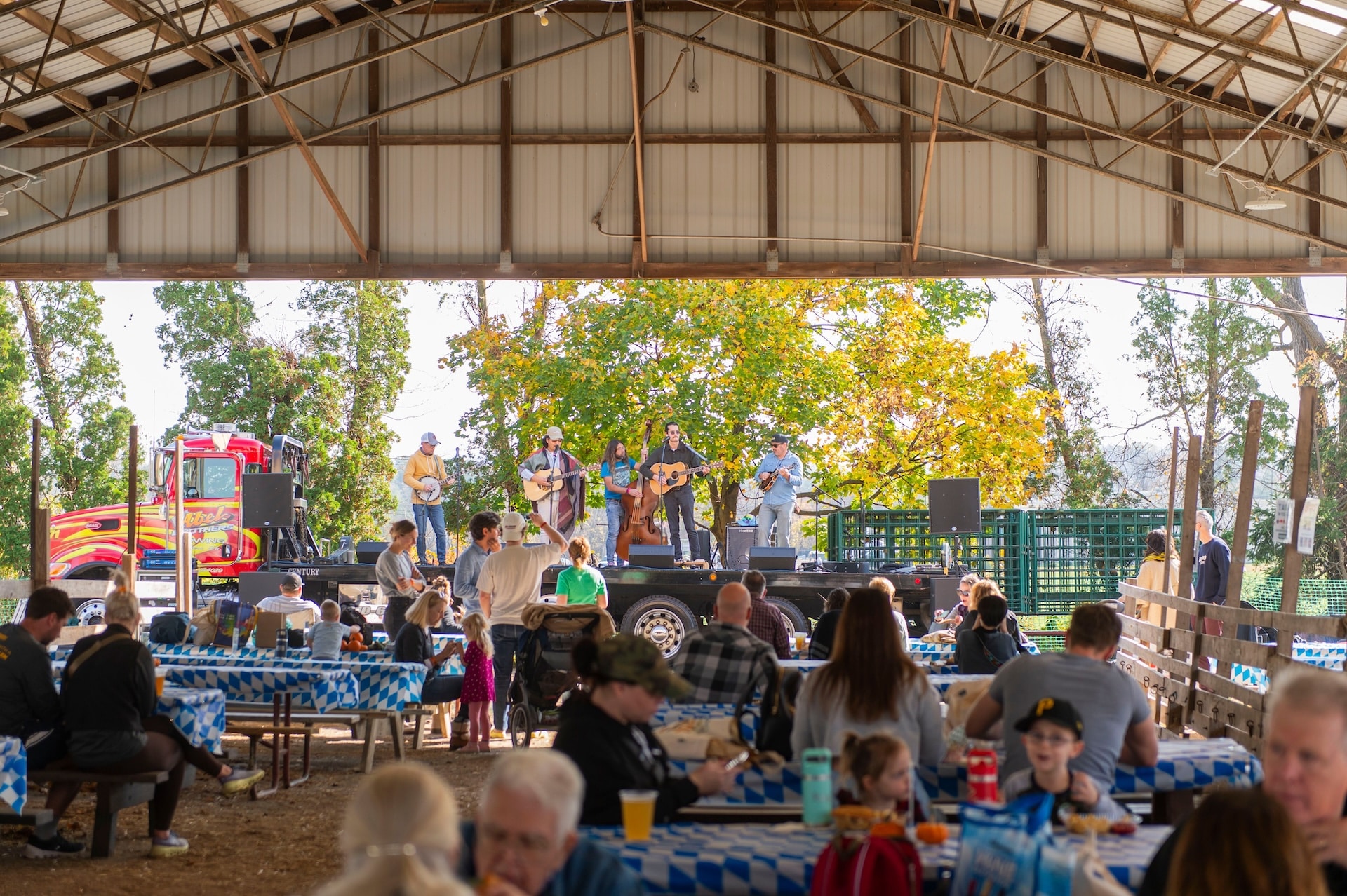 Crowd in picnic area with band playing behind them.