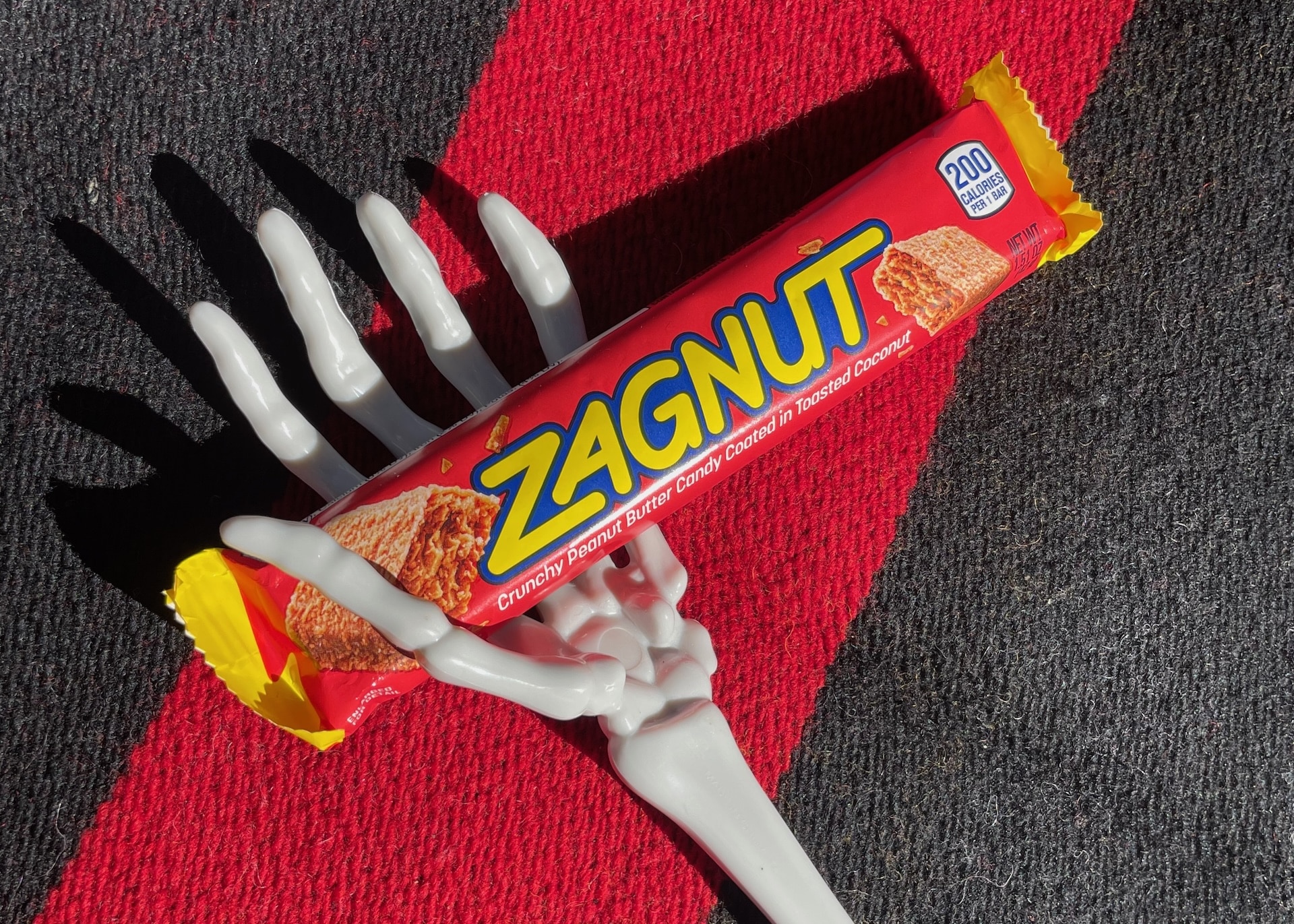 A skeleton hand holding a Zagnut candy bar.