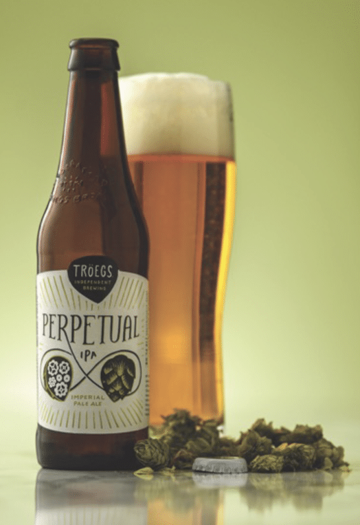 A bottle and glass of Perpetual IPA by Troegs Independent Brewing