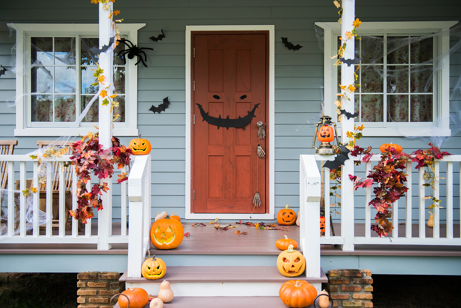 Halloween pumpkins and decorations outside a house.