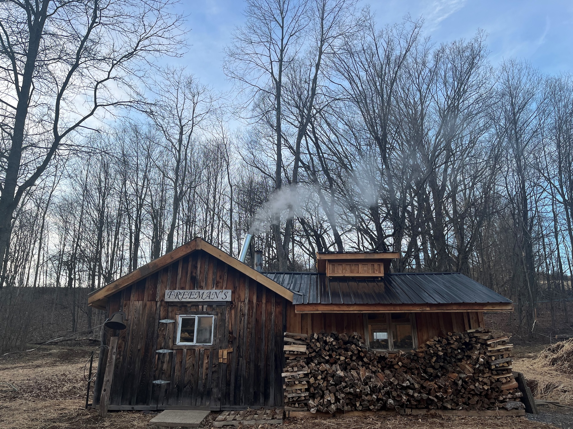 Freeman Family Farm cabin with stacked logs outside.