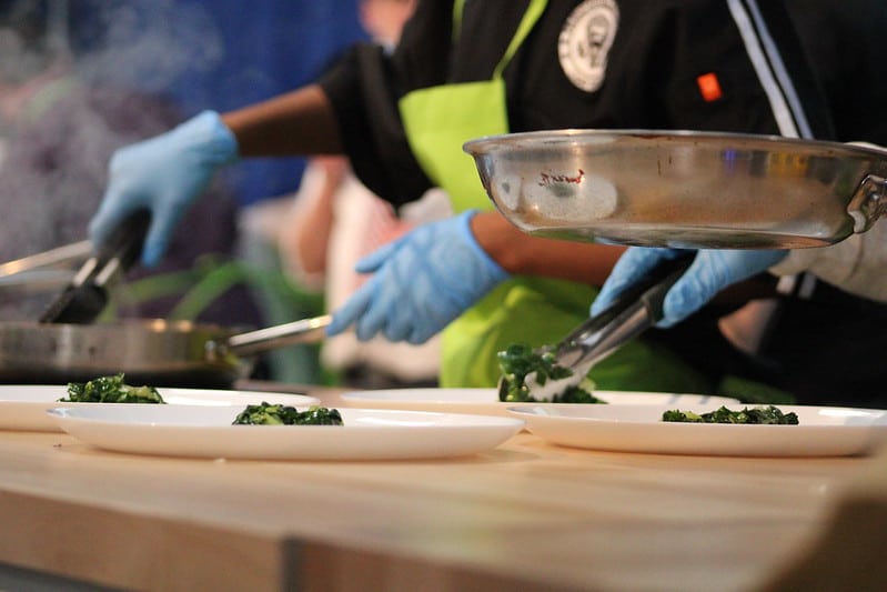 The Navy team plating their bok choy in the Army vs Navy Cook-Off at the 108th PA Farm Show.