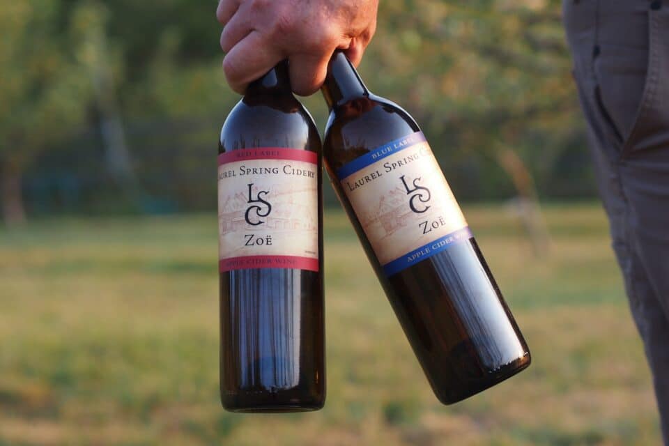 A hand holding two cider wines at Laurel Spring Cidery.