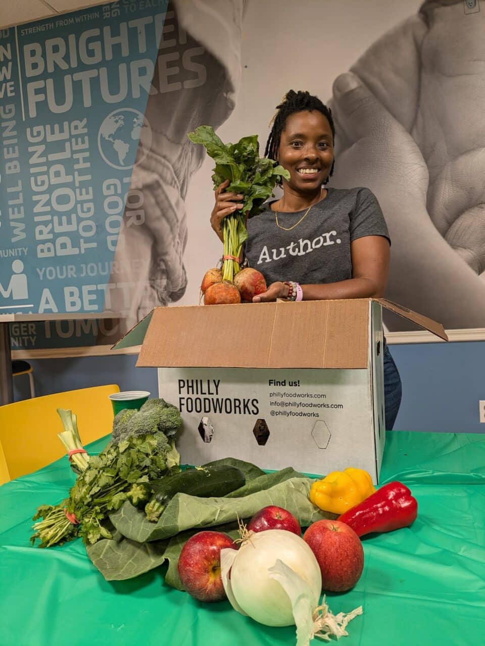 Stacey Woodson with a box of fresh produce.