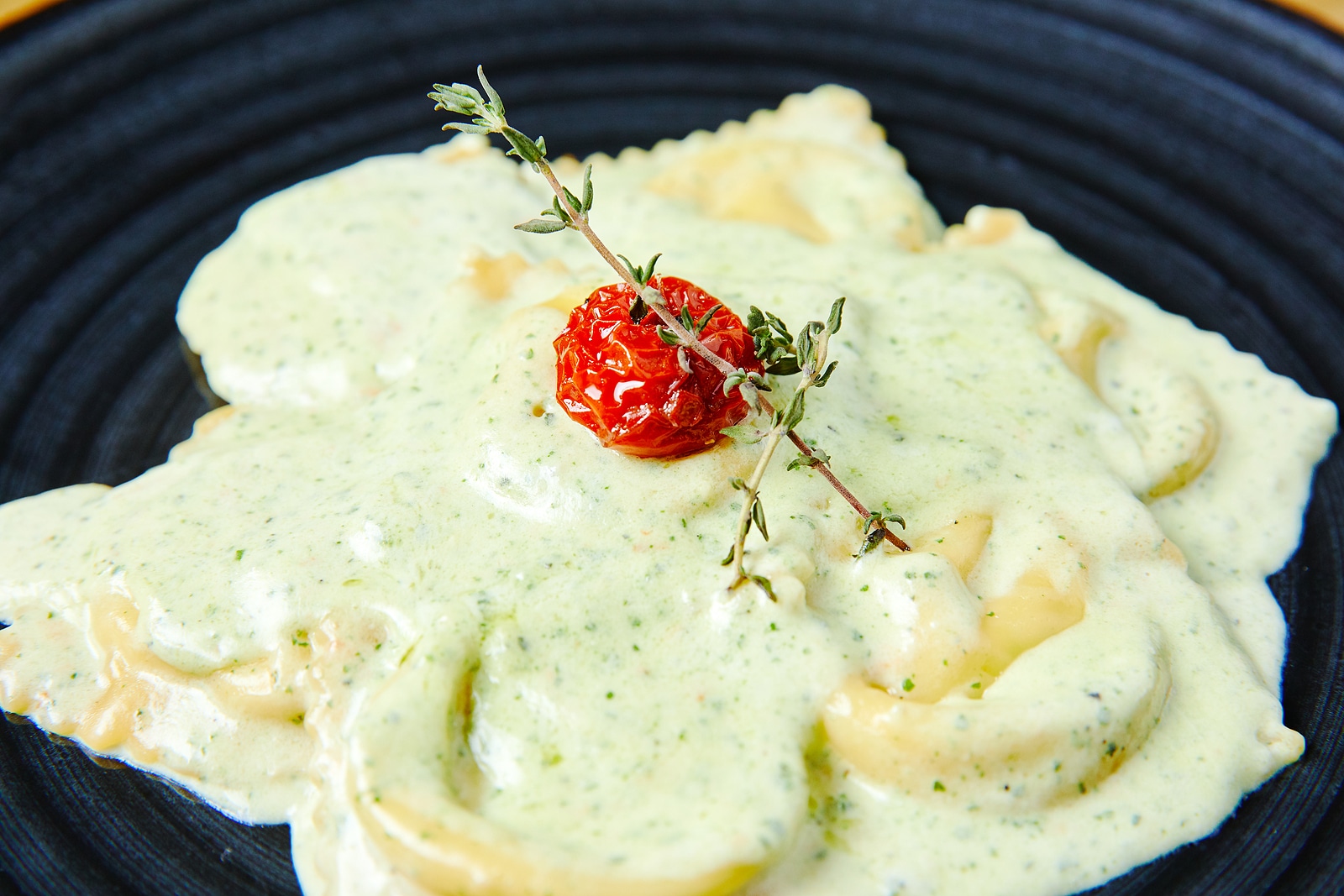 Ravioli with salmon in creamy sauce with pesto.